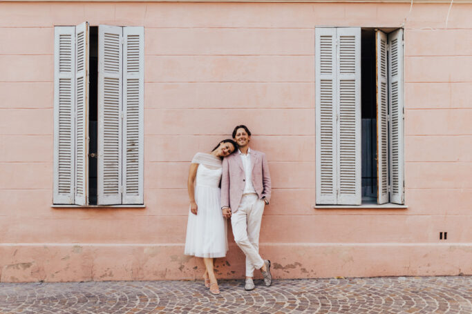 Couple against pink wall in Cannes France
