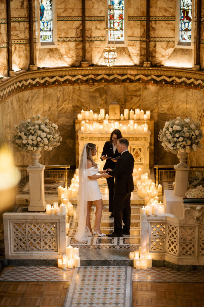 Bride and groom having candlelit wedding in Fitzrovia chapel