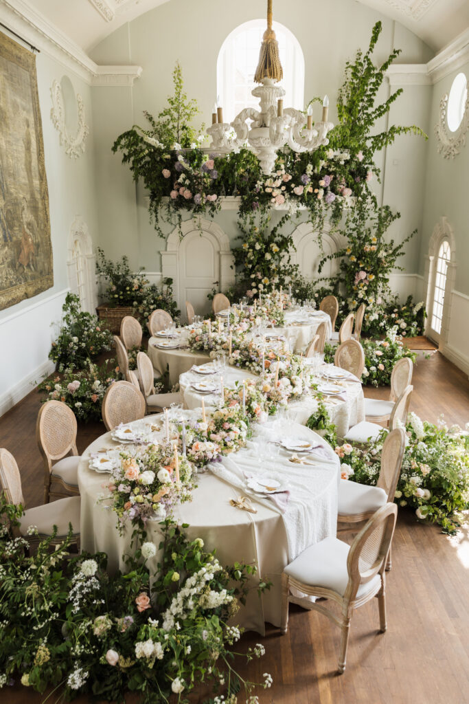 Round snake tables wedding breakfast with florals across it