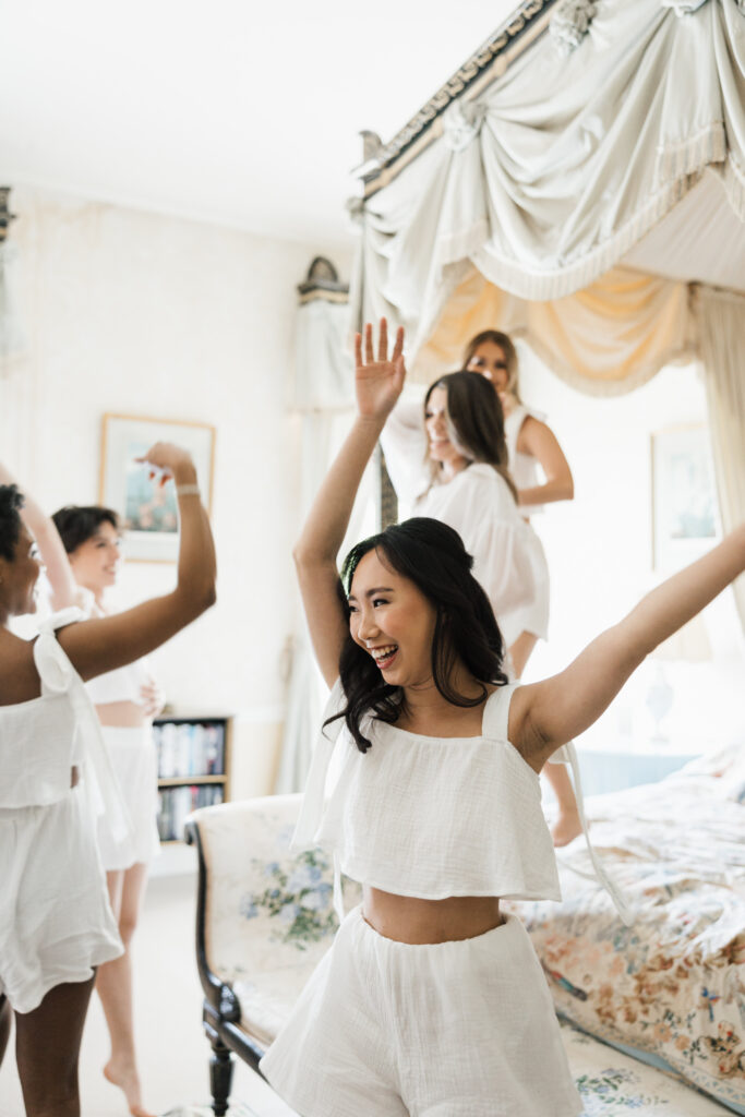 bridesmaids lying on the bed getting ready wearing white pjs