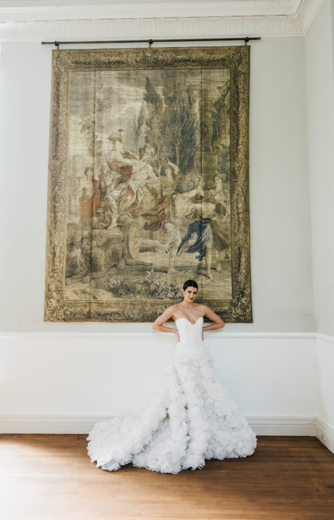 bride standing infront of tapestry