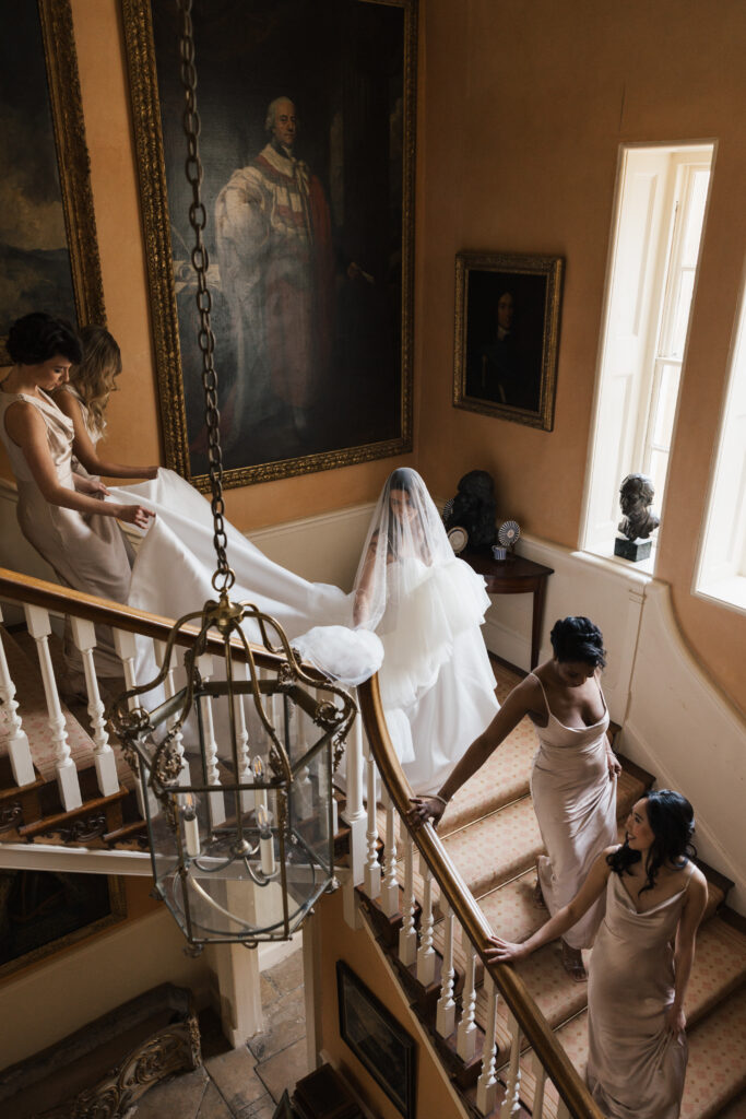 photo of bride and bridesmaids walking down the stairs