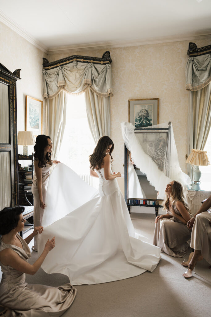 bride and bridesmaids in cornwell manor room holding bouquets