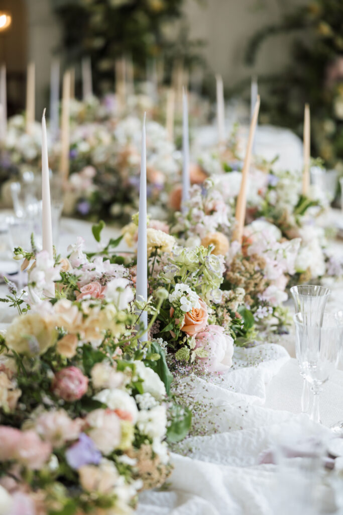 pastel floral arrangement with candles on round tables