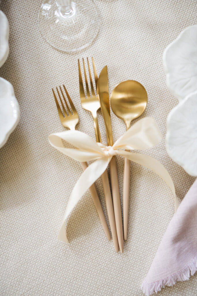 gold cutlery tied with ribbon