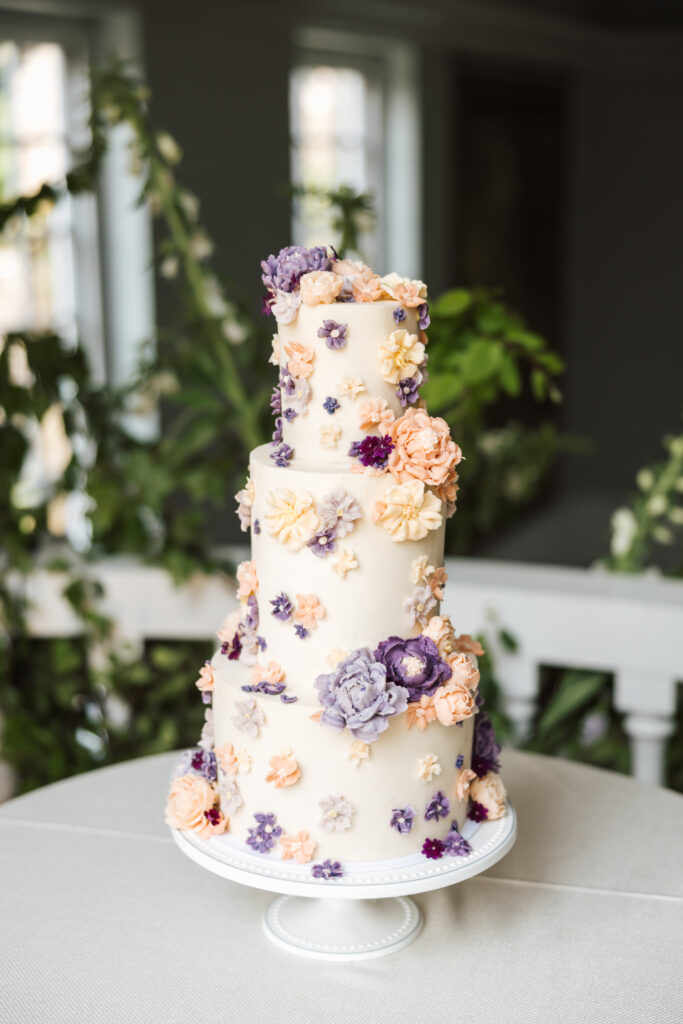 wedding cake with purple and pink flowers on it