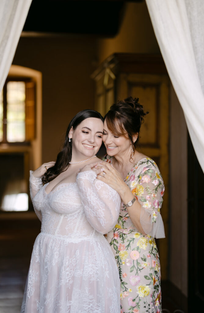 mother of the bride and bride hugging