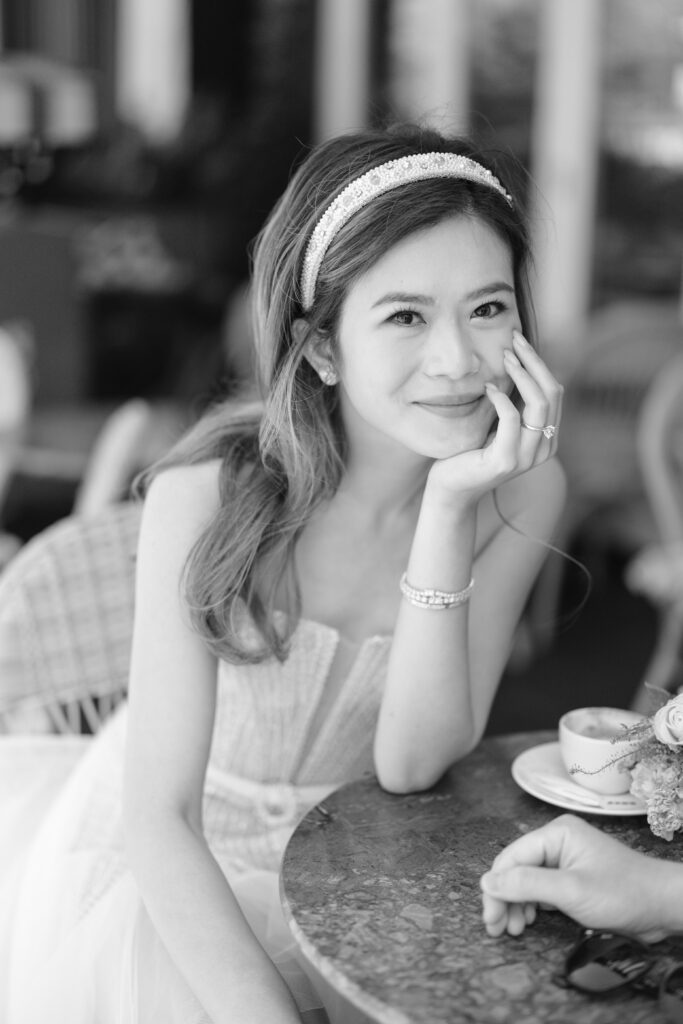 black and white photo of girl resting on table
