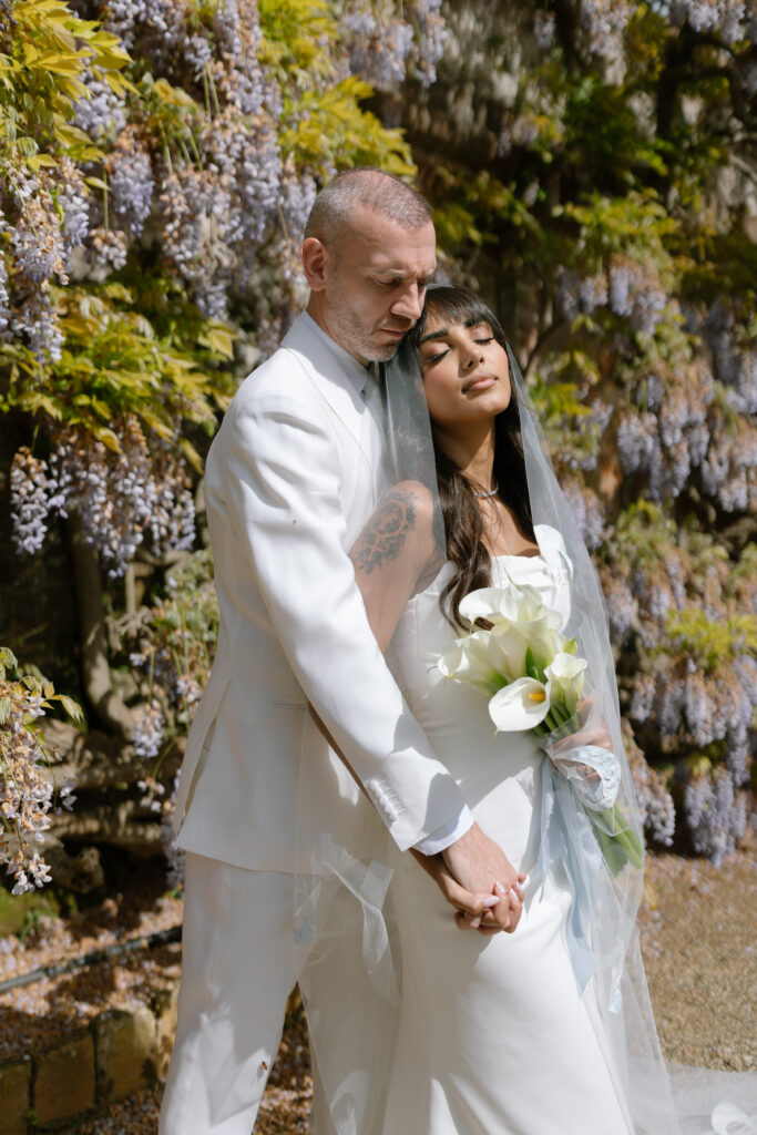 bride and groom infront of wisteria