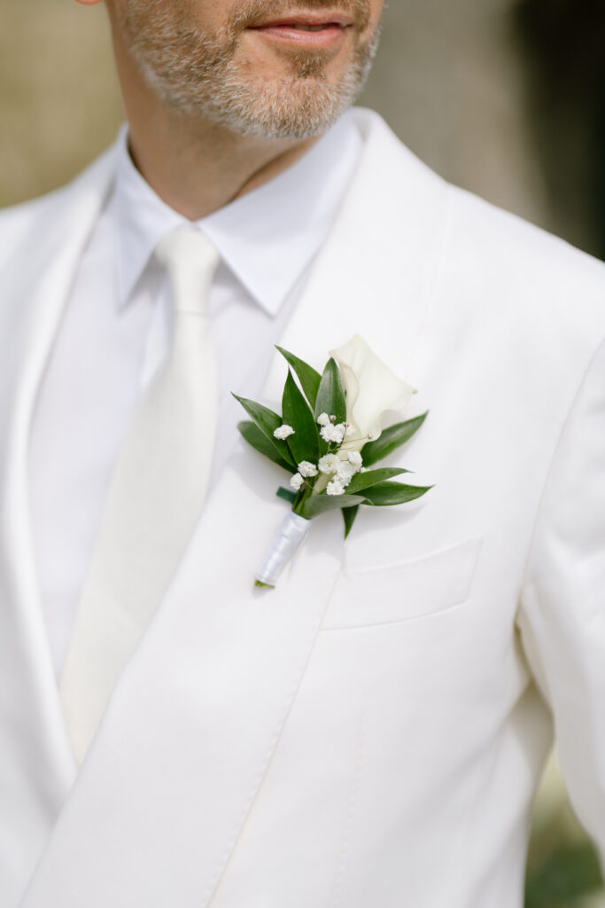 groom wearing white suit