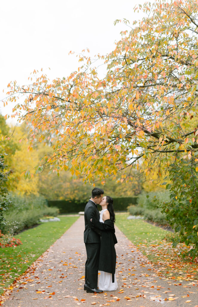 A man and woman kissing under a tree.