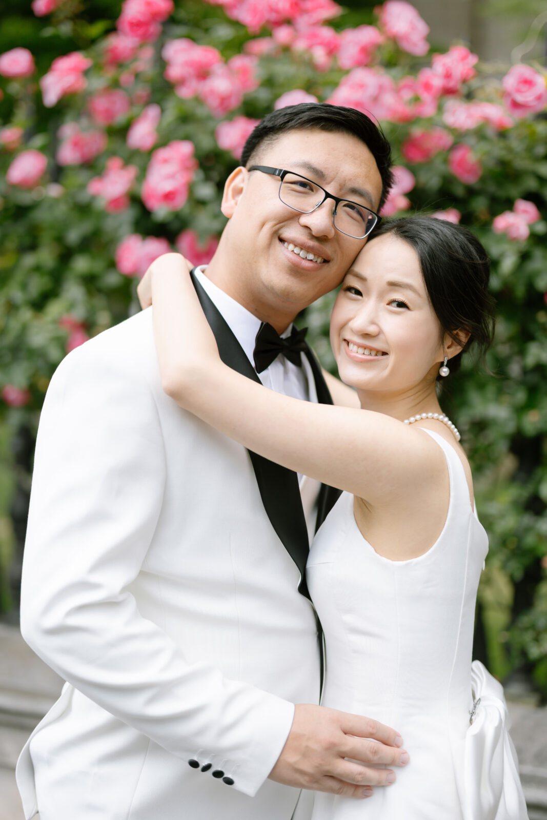 A man and woman in white dress and black tie.