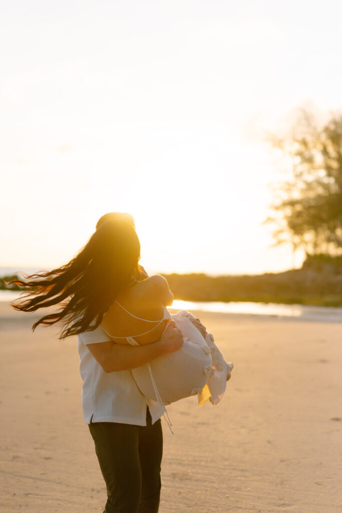 A woman holding a woman on a beach.