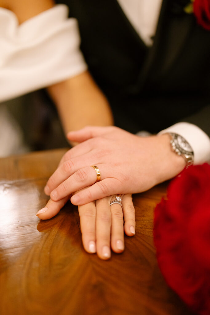 A couple hands with wedding rings on each other.
